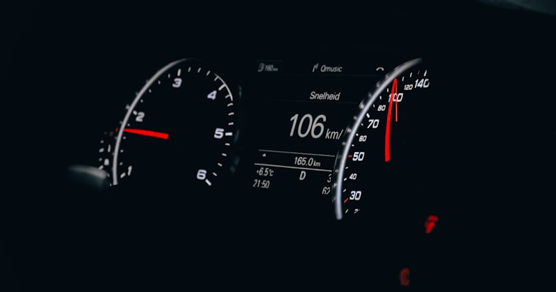 Car dashboard showing speedometer and odometer for mileage tracking